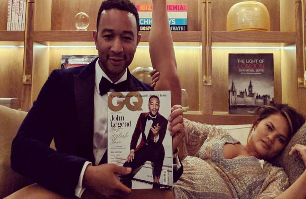 John Legend poses with his wife Chrissy Teigen holding copy of himself on the cover of GQ magazine (photo courtesy of John Legend Instagram)
